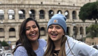 两个学生在罗马竞技场外一起微笑.